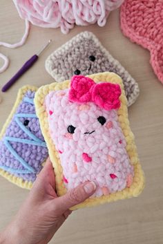 someone is holding up a crocheted cell phone case with a pink bow on it