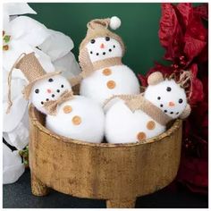 four snowmen in a wooden basket on a table