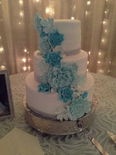 a wedding cake with blue flowers on it