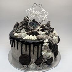 a cake decorated with oreo cookies and white frosting on top of a silver platter