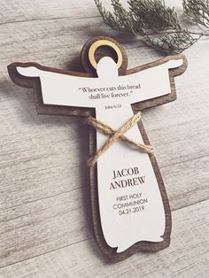 a wooden crucifix ornament with a name tag attached to it