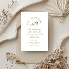 the wedding card is surrounded by dried flowers and paper fan fans, which are also on display