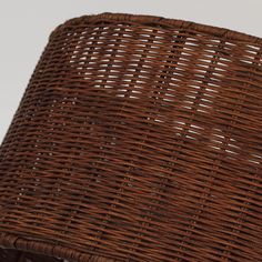 a brown wicker lamp shade sitting on top of a wooden table