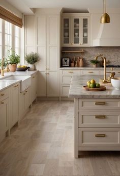 a kitchen filled with lots of white cabinets and counter top space next to a window