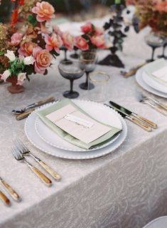 the table is set with place settings and silverware for an elegant wedding reception or special event