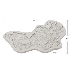 a white cookie mold with an intricate design on it