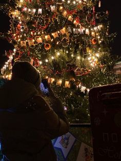 a person taking a photo of a christmas tree