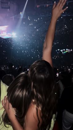 two people at a concert with their arms in the air