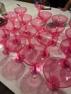 many pink wine glasses sitting on top of a table