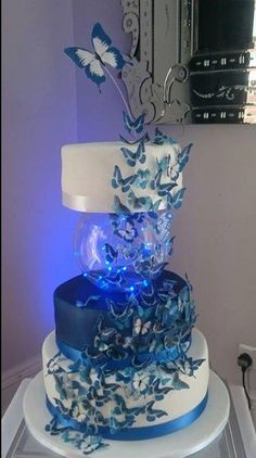 a blue and white wedding cake with butterflies on it