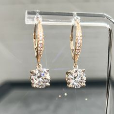 Moissanite offers timeless beauty and exceptional value. Our premium earrings feature GRA certified VVS1 clarity D color Moissanite hand set on high quality durable basket settings. This is the best compromise between cheap fakes (CZ, crystal, rhinestone) and extremely expensive diamond studs. Natural diamond equivalent earrings cost $10,000 - $100,000+. Get the same look at a reasonable price. Order yours today! -2.00 Carat 8MM main stones. 28MM Length. -Best of Breed VVS1 Clarity D color GRA certified Moissanite Stones -Exceptionally Cut for ideal light refraction. Excellent Rating.  -More Fire and Brilliance than Cheap Priced Moissanite online -9.25 Hardness Rating (will never dull). Diamonds are rated 10, fake diamonds are only 3-4.  -Solid 14K gold for the best balance of beauty and d Elegant Diamond Cut Moissanite Earrings, Elegant Moissanite Earrings With Diamond Cut, Elegant Moissanite Earrings With Prong Setting, Elegant Moissanite Hoop Earrings, Elegant Diamond White Earrings With Lever Back, Diamond White Moissanite Drop Earrings, Dazzling Moissanite Earrings With Prong Setting, Moissanite Drop Earrings With Diamond Accents, Exquisite Moissanite Earrings For Anniversary