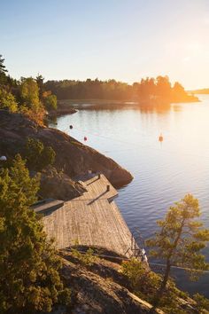 the sun is setting over a dock on a lake