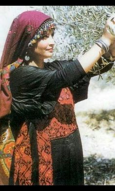 a woman holding an olive tree in her hand