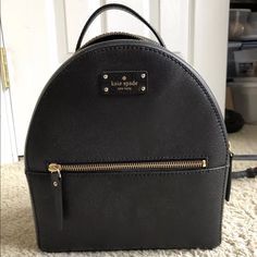 Kate Spade New York Grove Street Sammi Leather Backpack Purse In Black Leather With 14-Karat Light Gold Plated Hardware With Exterior Zipped Pocket. Interior: 1 Zipped Pocket And 1 Slip Pocket. Approx. Dimensions: 9.5" H X 9" W X 4" D. Fully Lined In Kate Spade Signature Fabric. Top Zip Closure. Elegant Black Backpack With Gold-tone Hardware, Kate Spade Backpack With Zipper Closure, Elegant Kate Spade Backpack With Detachable Strap, Elegant Kate Spade Backpack For Errands, Elegant Black Kate Spade Backpack, Kate Spade Leather Backpack With Zipper Closure, Kate Spade Leather Backpack With Zipper, Elegant Kate Spade Satchel Backpack, Classic Kate Spade Backpack With Zipper Closure