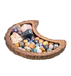 a wooden bowl filled with lots of different colored rocks and stones on top of it