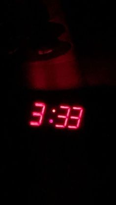 a digital clock with red numbers on it in the dark