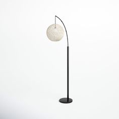 a black floor lamp with a white ball on it