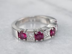 a diamond and ruby ring on a marble surface