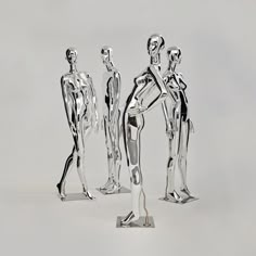 three silver figurines standing next to each other