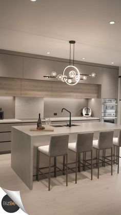 a modern kitchen with an island and bar stools