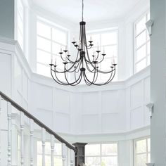 a chandelier hanging from the ceiling in a room with white walls and windows