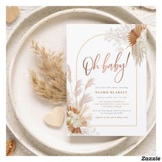 a white plate topped with a card next to some dried flowers and hearts on top of it