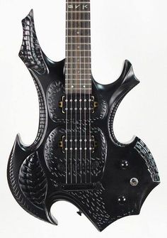 a black electric guitar with an intricate design on it