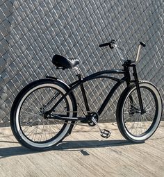 a black bicycle parked next to a metal fence