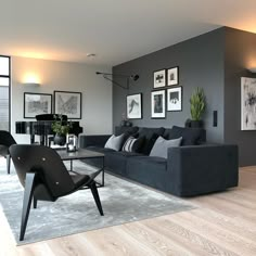 a living room filled with black furniture and pictures on the wall above it's windows