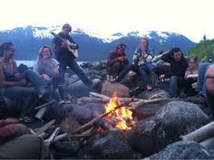 a group of people sitting around a campfire