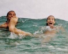 two people swimming in the ocean on surfboards