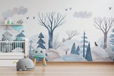 a baby's room decorated in blue and white with trees, birds and clouds