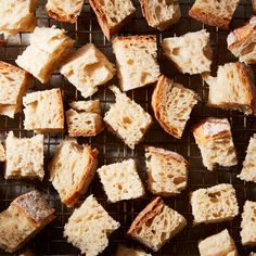 pieces of bread are on a cooling rack and some have been cut into cubes