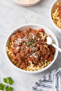 two bowls of pasta with meat sauce and parmesan cheese