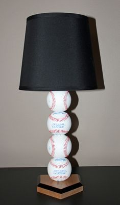 a lamp that is sitting on top of a table with a baseball ball on it