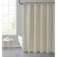 a bathroom with a white tub and shower curtain