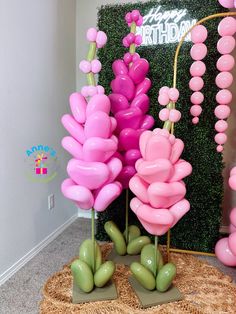 pink and green balloons in the shape of flowers on display at a birthday party or celebration