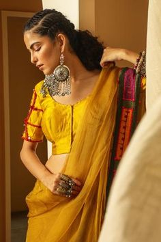 Yellow blouse with deep back, placement mirror work and hand embroidered sleeves.
Component: 1
Embroidered
Neckline: Round
Sleeve Length: Half
Fabric: Handwoven Chiniya Silk
Color: Yellow
Backless blouse
Closure: Concealed front placket
Note: Saree worn by the model is not for sale - Aza Fashions Mirror Work Saree Blouse, Yellow Mirror, Mirror Work Saree, Saree Blouses Online, Yellow Saree, Backless Blouse, Silk Saree Blouse, Yellow Silk, Blouse For Women