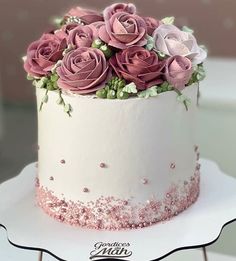 there is a white cake with pink roses on it