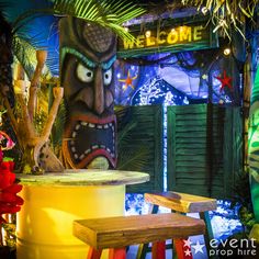 a tiki statue sitting in front of a welcome sign