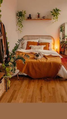 a bedroom with wooden floors and plants on the wall above the bed, in front of a mirror