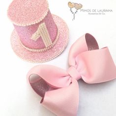 a pink hat with a bow on it next to a pair of baby's shoes