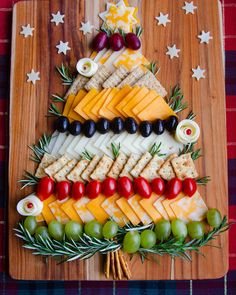 a christmas tree made out of cheese, crackers and olives on a cutting board