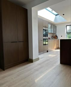 an empty kitchen with wood floors and skylights