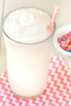 a glass filled with milk and sprinkles next to a bowl of cereal