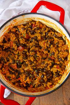 a large pot filled with lots of food on top of a wooden table