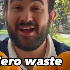 a man holding two oranges with the words zero waste written on it in front of him