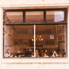 several people sitting in a window with their laptops