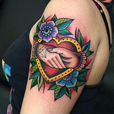 a woman with a tattoo on her arm holding a diamond in the shape of a heart