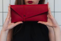 Simple but unique women's clutch with unusual rubber band closure will give your outfit a nice touch. The clutch comes with three coloured rubber bands which you can easily swap based on the occasion or your mood. Dimensions: 26 x 13 cm Made of high-quality vegetable tanned full grain leather. Each piece is original. Would you like to add initials or full name to the product? Or would you like the clutch to have a different thread colour? Just let me know and we will definitely figure something Trendy Leather Party Clutch, Envelope Clutch For Daily Use, Chic Clutch With Magnetic Closure As Gift, Party Clutch In Soft Leather, Daily Use Envelope Pouch, Red Pouch As Gift, Red Pouch As A Gift, Trendy Formal Clutch Wallet, Clutch With Magnetic Closure As Gift